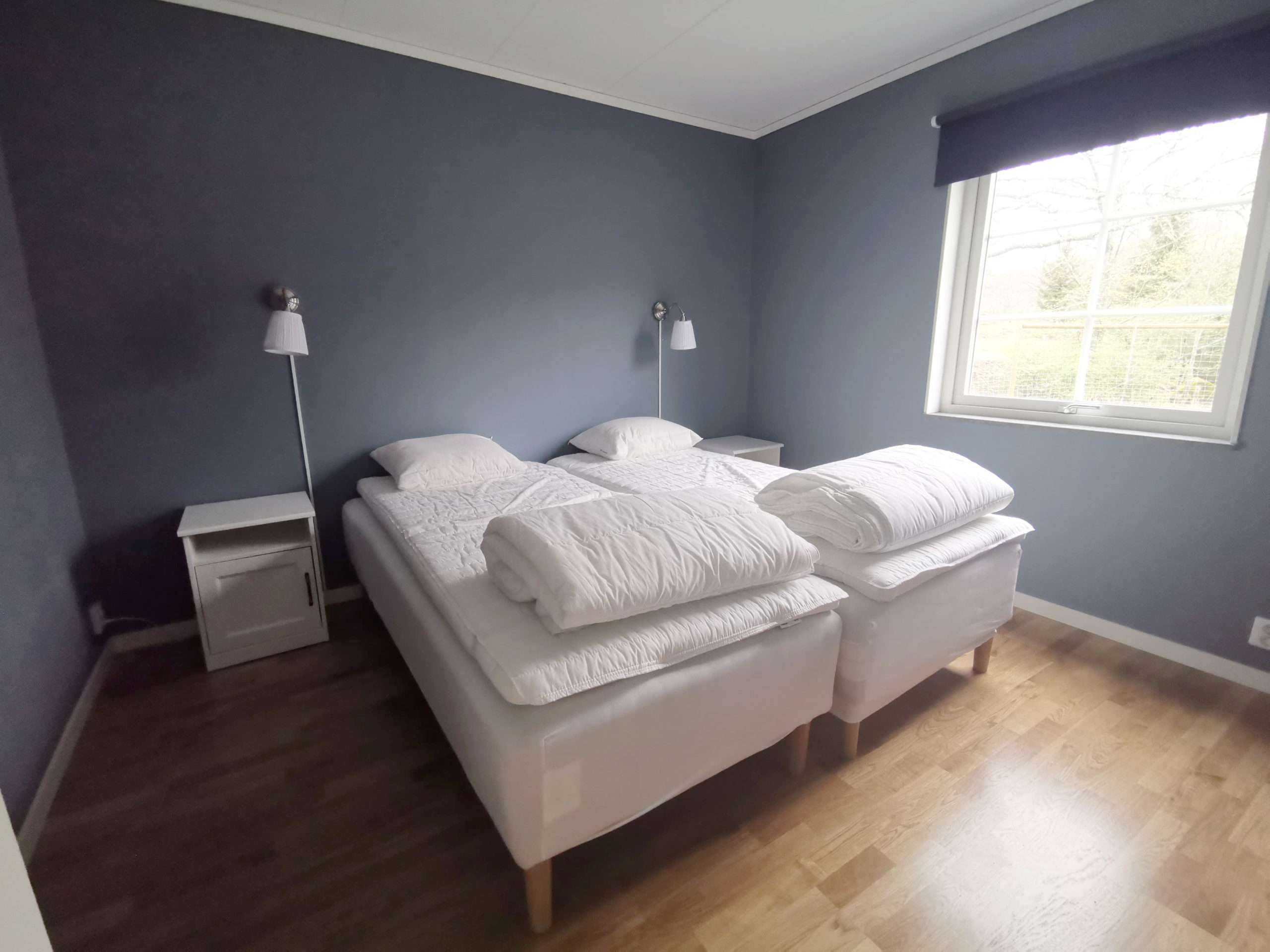 Bild på sovrum med dubbelsäng i stuga på Basunda Gård