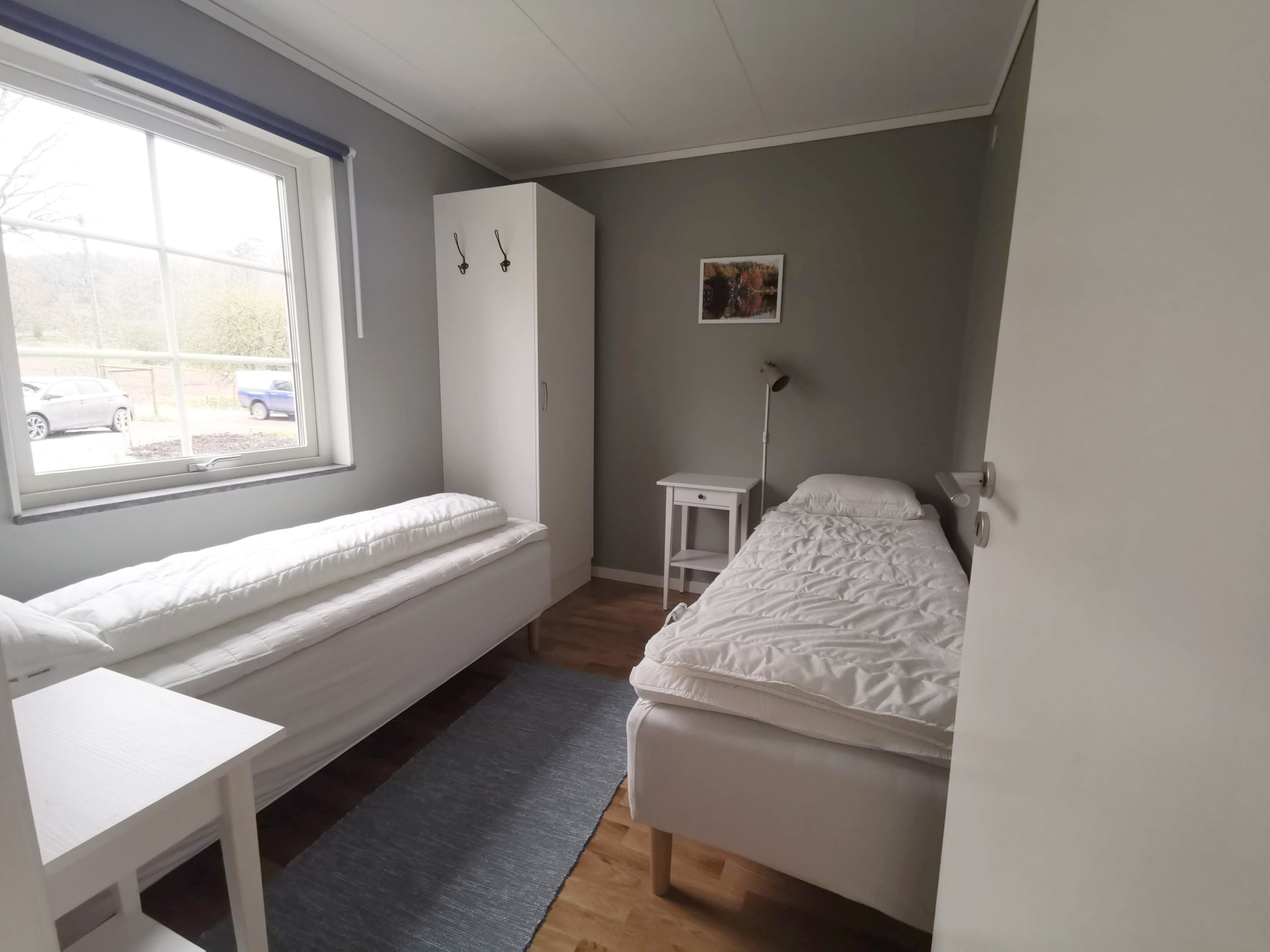 Bild på sovrum med enkelsängar i stuga på Basunda Gård